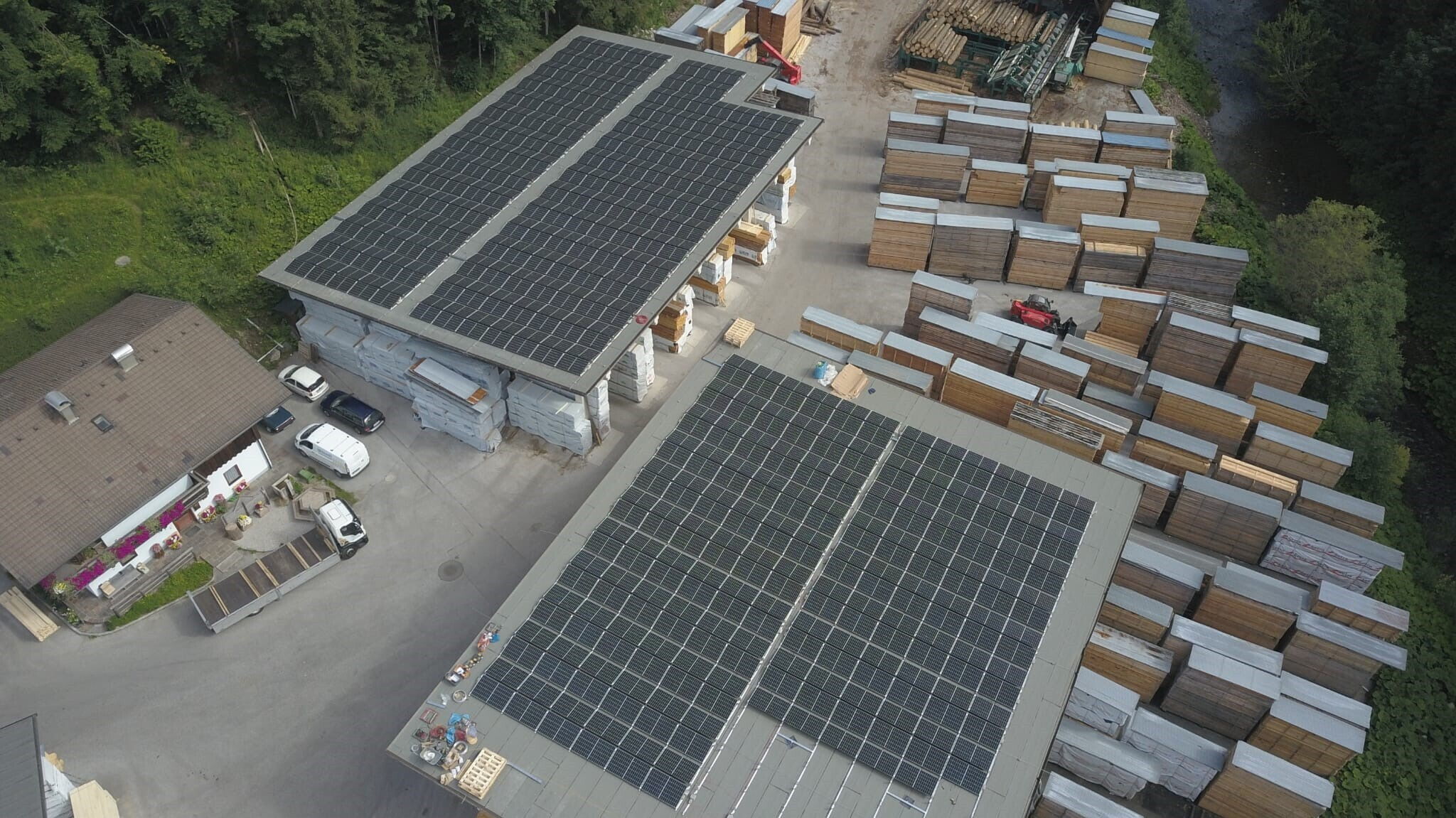 Zwei Lagerhäuser mit Solaranlagen auf dem Dach und mehrere Boxen neben den Lagerhäusern