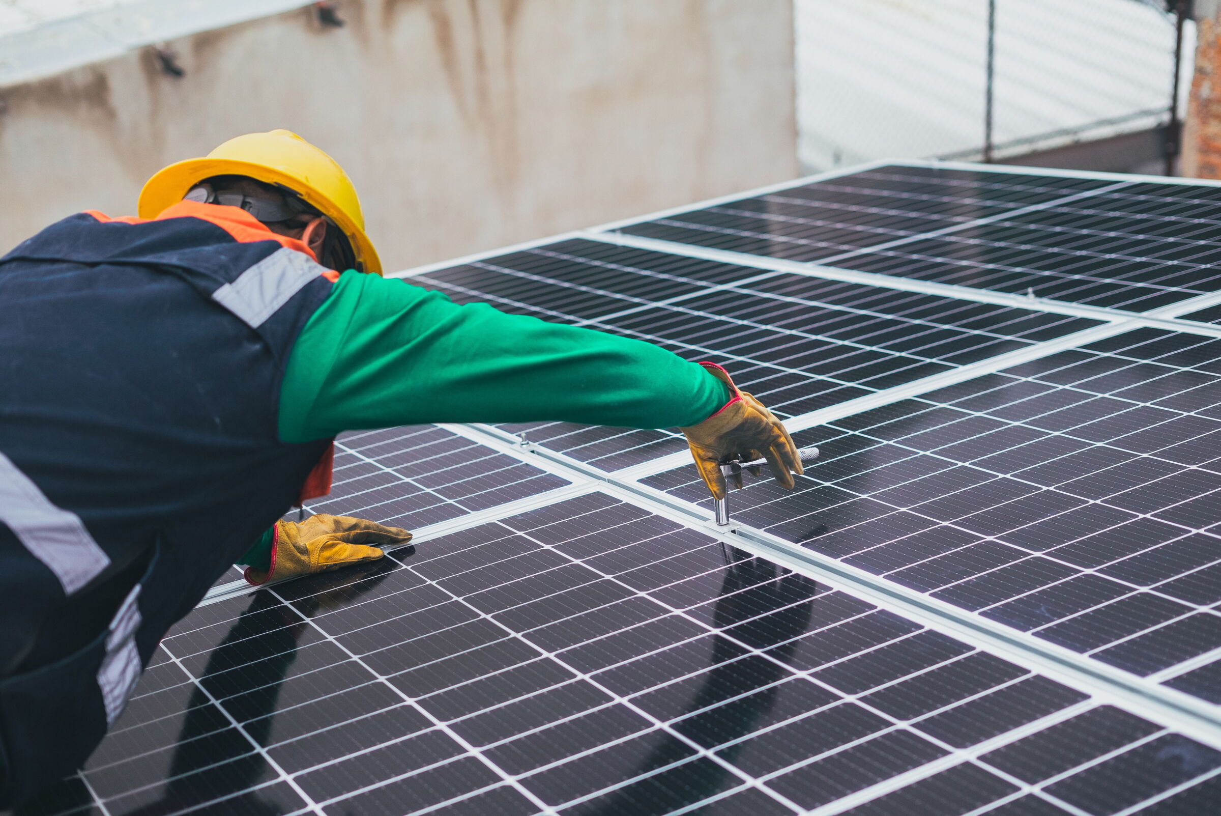 Ein Elektriker montiert ein Photovoltaik Panel