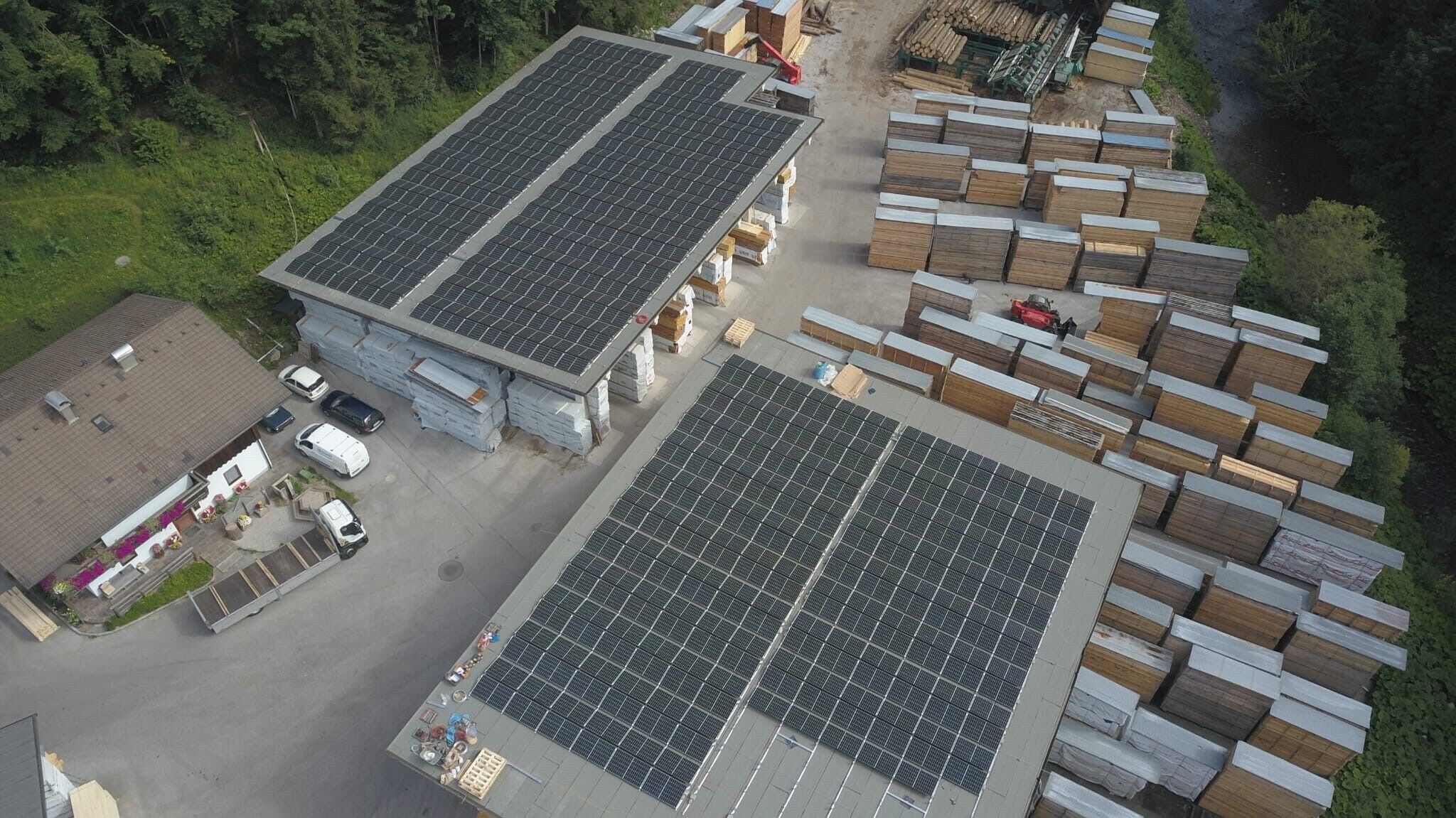 Zwei Lagerhäuser mit Solaranlagen auf dem Dach und mehrere Boxen neben den Lagerhäusern
